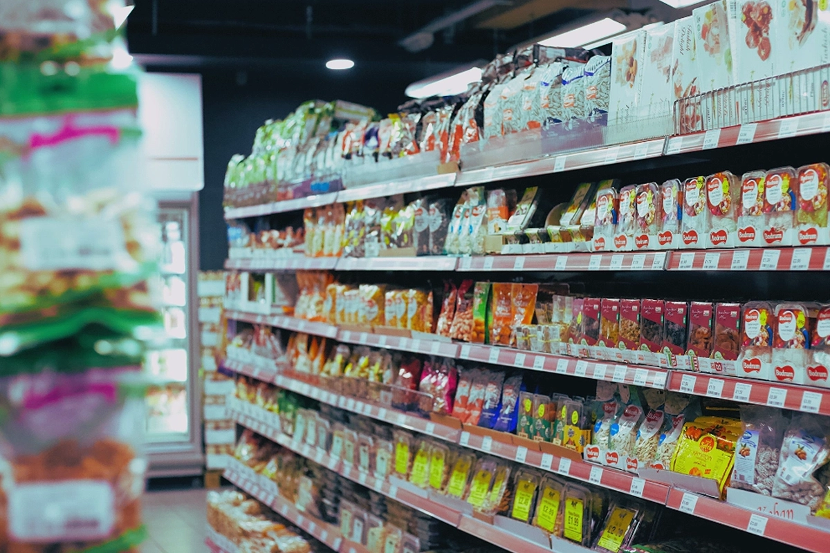 Aisle in a Japanese supermarket showcasing a diverse selection of packaged foods, exemplifying the vibrant Food and beverage market Japan.