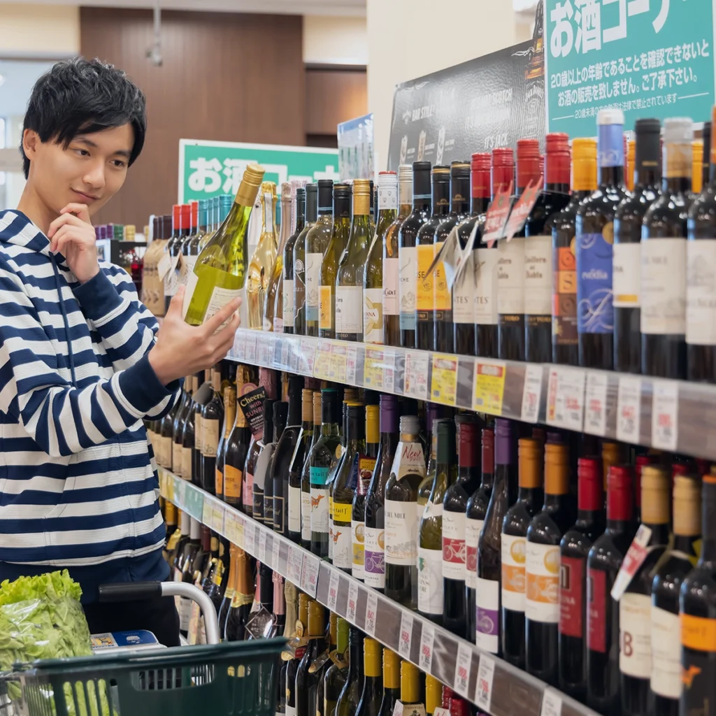 Japanese consumer selecting imported wine at a retail store